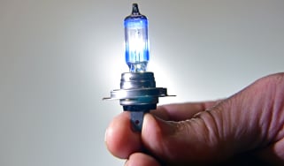 Hand holding a headlight bulb